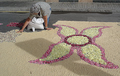 Mujer haciendo una alfombra de flores